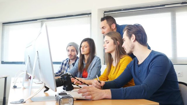group of young cool hipster creative business people student with teacher in photography school editing photo with desktop computer and graphic tablet