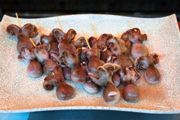 Japanese street food in Kyoto. Raw octopus on sticks