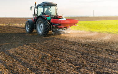 Obraz premium Tractor spreading artificial fertilizers