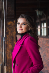 Fototapeta premium attractive young woman in pink coat on the street
