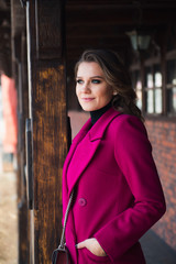 attractive young woman in pink coat on the street