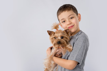 Little boy with Yorkshire Terrier dog isolated on white background. Kids pet friendship