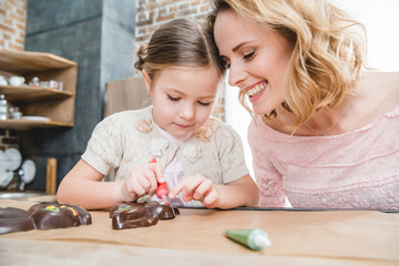 Mother and daughter icing chocolate rabbits