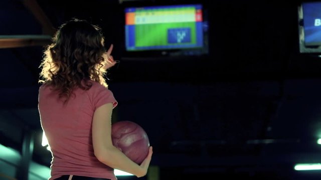 Young woman is throwing ball in a bowling club Slow motion
