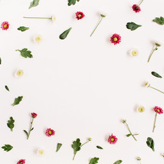 Frame wreath with red and white wildflowers, green leaves, branches on white background. Flat lay, top view. Flower background.