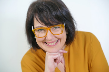 Cheerful mature woman with yellow eyeglasses, isolated