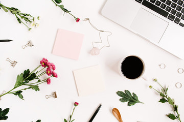 Top view home office table desk pattern. Workspace with laptop, wildflowers bouquet, coffee cup, feminine accessories and office stuff. Flat lay.