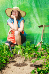 woman with gardening tool working in greenhouse