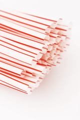 Red and white drinking straws on the white - studio shot