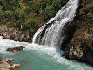Fototapeta na wymiar Turquoise Marsyangdi river and waterfall. Scene near Jagat, Annapurna Conservation Area, Nepal.