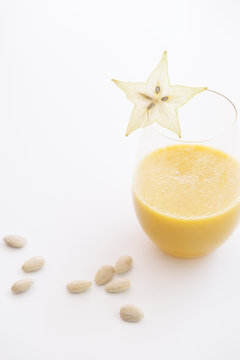 Fresh yellow fruit juice, smoothie, with almonds, oranges, pineapple, star fruit and bananas