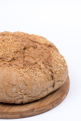 Round domestic bread isolated with wooden board