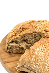 Round domestic bread sliced on the wooden board