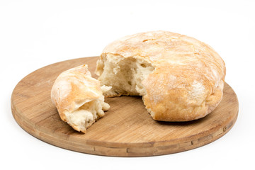 Round domestic bread sliced on the wooden board