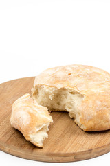Round domestic bread sliced on the wooden board