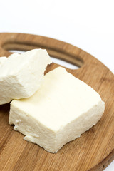 Slices of white feta cheese on the wooden board