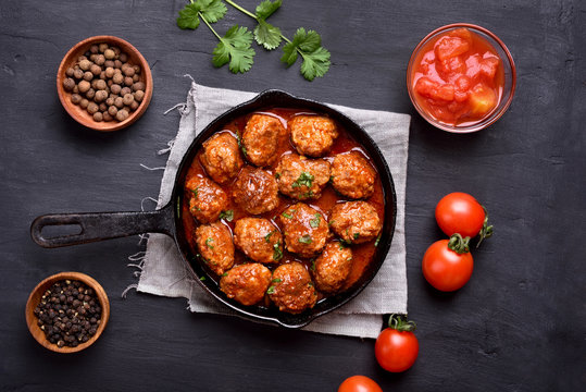 Meatballs with tomato sauce and green herbs