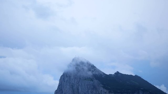 The Rock of Gibraltar and bird flying on blue cloudy sky, UK.