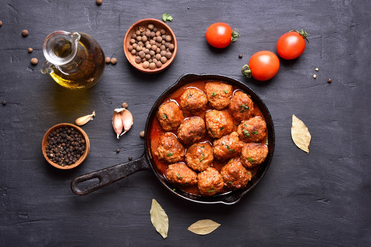 Meatballs with tomato sauce and green herbs