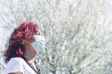 Girl or woman standing in the third frame under the flower tree, spring allergies