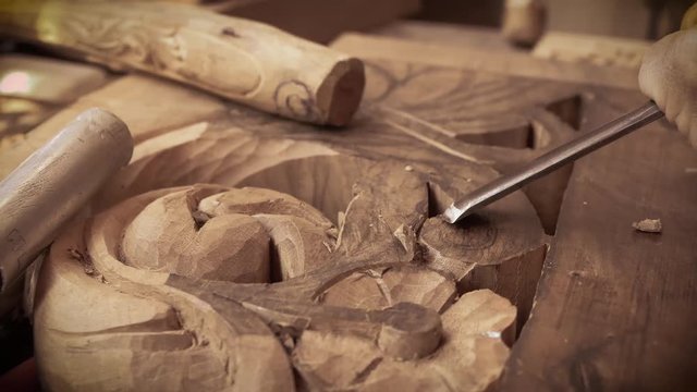 Wood carving. Carver with chisel and hammer. A skillful craftsman working on a panel of wood carve decoration