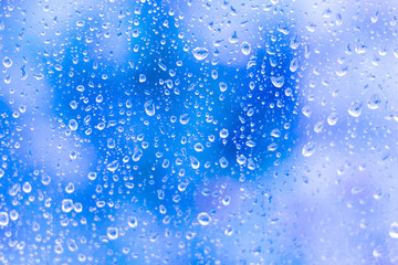 Naklejka na ściany i meble Water drops on glass on blue background-