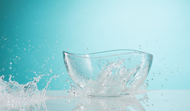 The water splashing to glass bowl on white background