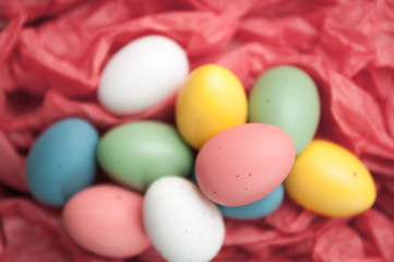 Fototapeta na wymiar Easter eggs piled up on a red background
