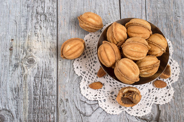  Cookies.   Homemade cookies in the form of a walnut, filled with sweet condensed milk and  almonds in a metal vase on a white openwork napkin.