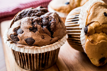 Chocolate and Vanilla Muffins on wooden surface.