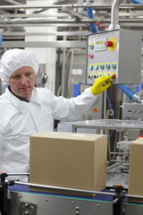 worker at control panel in factory - pressing buttons