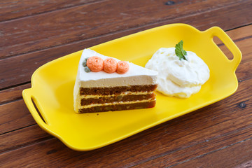 Carrot cake and whipped cream on wooden table 
