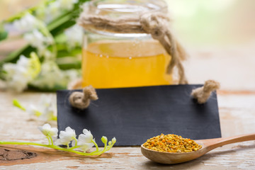 Honey and bee pollen on wooden table