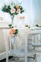 Interior design of white room with beautiful flowers on the served table. Big windows and creative classical mirror at the background. Horizontal