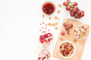 Healthy breakfast with yogurt, muesli, fresh fruits and berries, cereal, nuts on white background. Flat lay, top view.