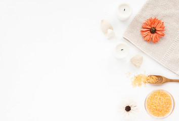 Spa composition. Sea salt, orange flowers, spa candles, bath towel on white background. Flat lay, top view