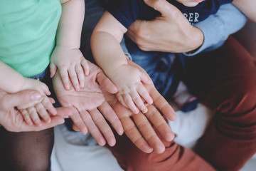 Father's and mother hands holding  hands children.Father and Mother Holding twins children. Child hands Closeup into Parents