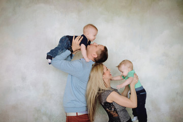 Father and mother playing with two little sons.Two little kid boys, siblings twins and parents having fun. Happy father, mother and two children playing together.