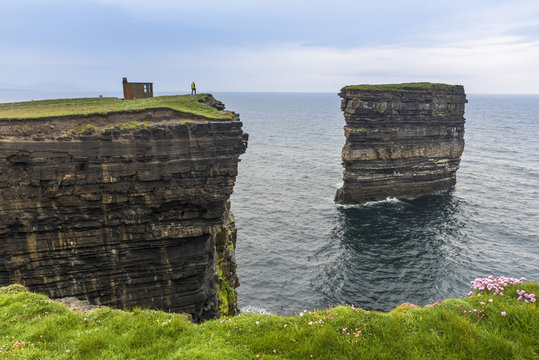 Downpatrick Head, Ballycastle, County Mayo, Donegal, Connacht region, Ireland, Europe. A man watching the sea stack from the top of the cliff.