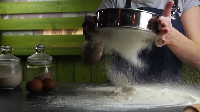 cook sifts the flour for the dough