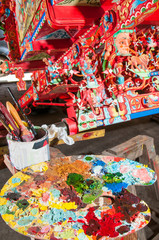 Colorful palette of a sicilian cart painter: workshop of folkloric craftsmanship Rosso Cinabro in Ragusa Ibla, Sicily