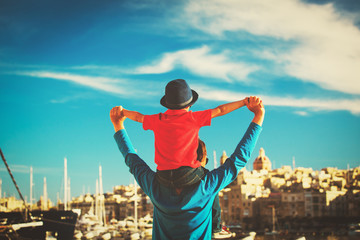 Fototapeta na wymiar family travel - father and son on shoulders play at sky