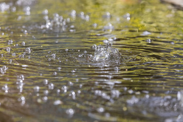 A weak jet of water with bubbles from the water surface