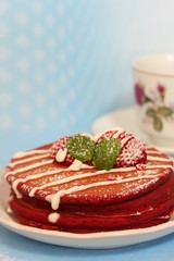 Stack of Red velvet pancakes against blue background, selective focus