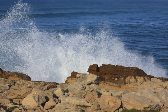 Marine wave breaks against offshore stone