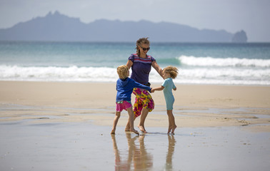 Happy woman and children on beach
