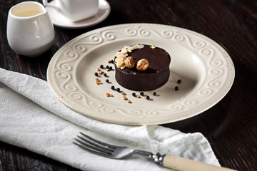 Beautiful decorated chocolate cake with golden nuts and a cup of coffee