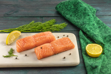 Two slices of salmon on dark background with copyspace