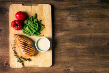 Marinated grilled healthy chicken breast served with vegetables, copy space for text