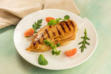 Grilled chicken fillet with cherry tomatoes and salad leaves